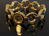 a close up of a gold bracelet on a black surface