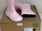 une paire de bottes de pluie roses posée sur une boîte en carton
