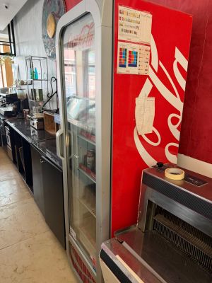 a coke machine in the middle of a long line of counter tops
