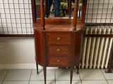 une petite armoire en bois surmontée d'un miroir