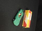a green toy car next to a box of cigarettes