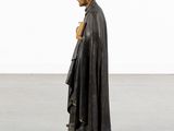 a statue of a man in a black cloak holding a book