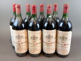 six bottles of wine are lined up in a row on a table