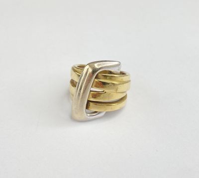gros plan d'une bague en or et en argent sur une surface blanche