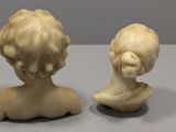 pair of white marble busts of a boy and a girl