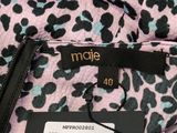 the label on a pink leopard print jacket is attached to the back of the jacket