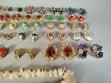 many different types of earrings and rings on the table