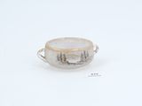 a close up of a cup on a white surface with trees in the background