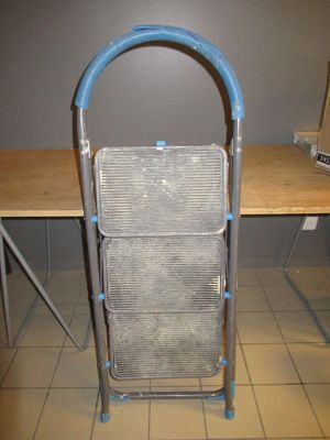 une image représentant une chaise en métal avec une poignée bleue