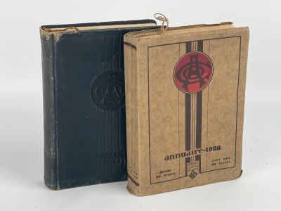 un vieux livre à la couverture rouge et noire posé à côté d'un livre noir