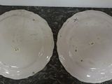 two white plates sitting on top of a marble counter top