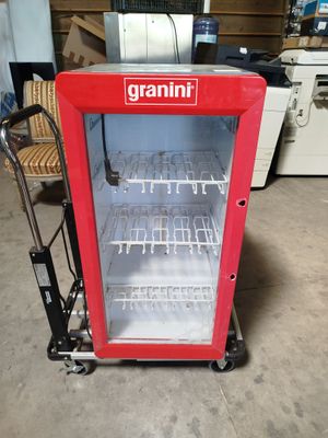 a small red refrigerator that is sitting in a garage