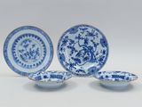 three blue and white plates with flowers and birds on them