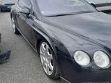 black bentley car parked in a parking lot with other cars in the background