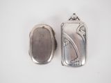 silver plated pill case and a silver pill case on a white surface
