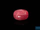 a close up of a red ruby stone on a black surface