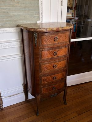 a tall wooden chest of drawers in the corner of a room