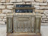 a close up of an old fashioned cash register with a stone wall in the background