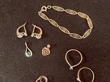 three pairs of gold and silver jewelry on a black surface