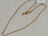 a gold chain necklace with a heart charm hanging from it ' s end