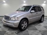 une photo d'un SUV Mercedes argenté garé sur un sol à damier