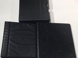three black leather folders sitting on top of a white table