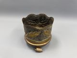an old brass cup with a fish design on it
