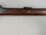 un vieux fusil accroché au mur à côté d'une clé
