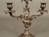 a silver candelab with three birds on it
