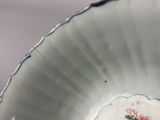 a white bowl with a blue and pink design on it