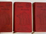 three red books sitting on top of a table next to each other