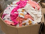 une boîte en carton remplie de vêtements pour bébés dans un entrepôt
