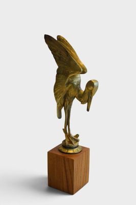 bronze sculpture of a bird on a wooden base