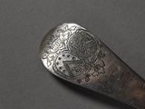 a silver spoon with a design on it on a table