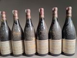 six bottles of wine are lined up in a row on a table