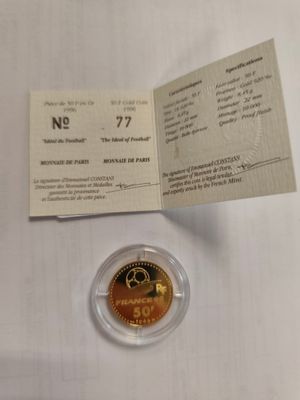 a close up of a gold coin on a table with a receipt
