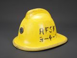 an old yellow hard hat with writing on the side of it