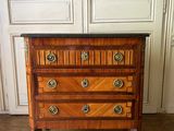 une petite commode en bois posée sur un parquet en bois massif
