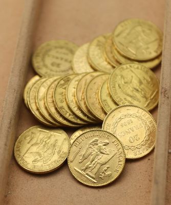 beaucoup de pièces d'or dans une boîte posée sur la table