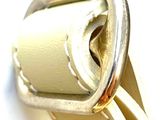 a close up of a white purse with a metal buckle