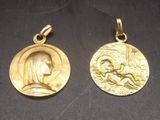 deux pendentifs en forme de médailles d'or représentant une femme et un homme