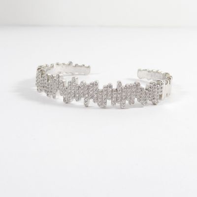 the bracelet is made out of silver metal and has a cross design