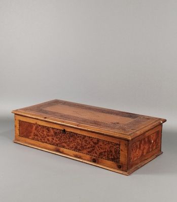 une vieille boîte en bois posée sur une surface grise