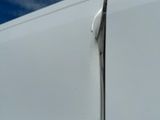a close up of a white van with a broken door