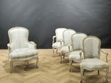 four white chairs in a room with a black wall behind them