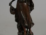 an image of a bronze statue of a woman holding a basket