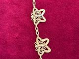 a close up of a necklace on a pink surface