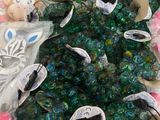 a pile of green and blue beads and a teddy bear