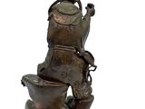 a bronze statue of a man sitting on top of a toilet