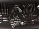 a lot of silverware on a table with spoons and spoons